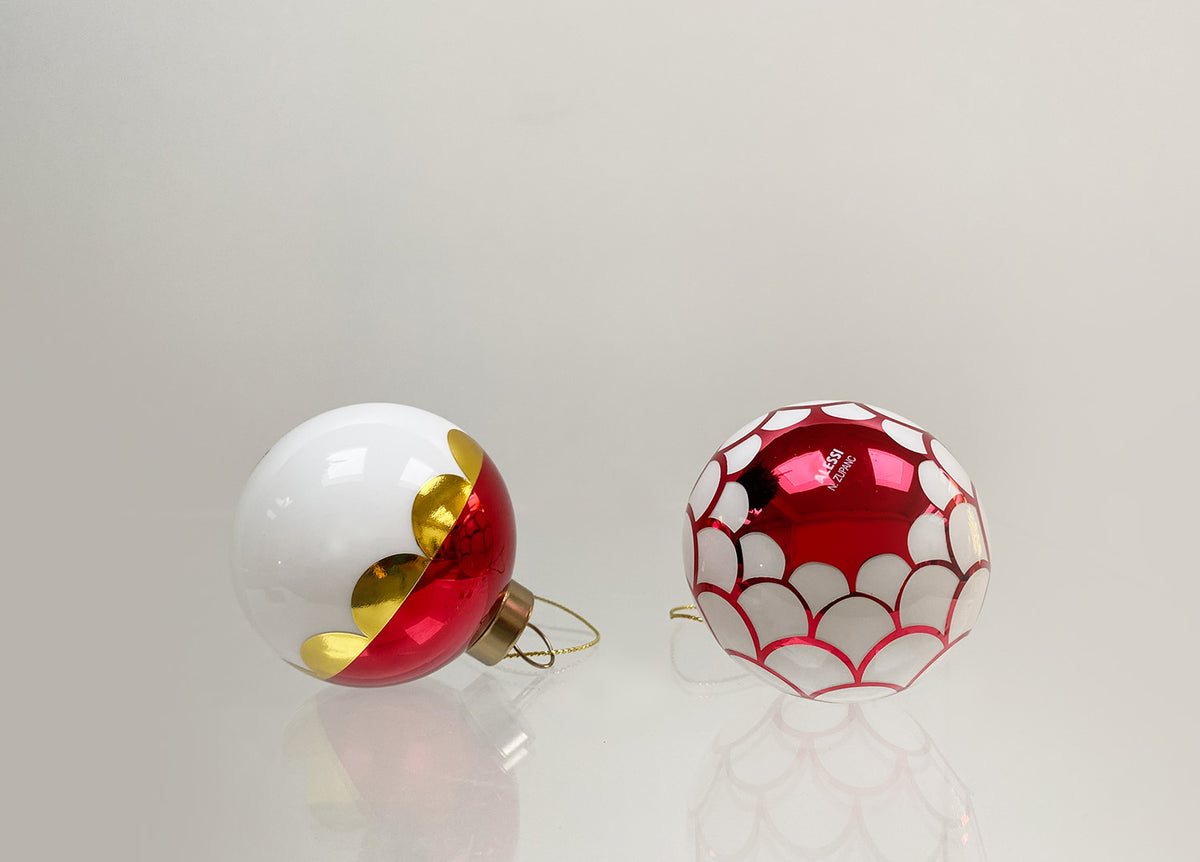 Twee kleine glazen kerstballen: één rood-wit-goud, één met rood-wit schubbenpatroon