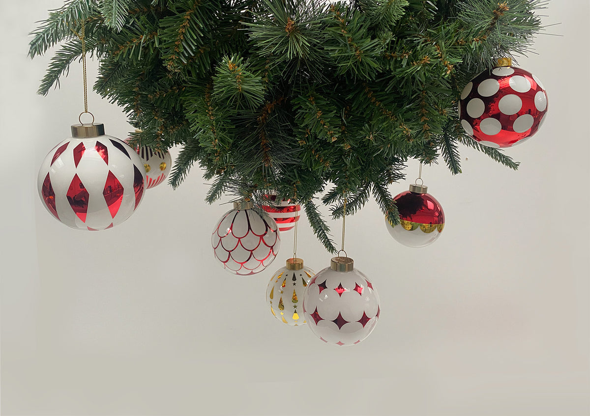 Grote en kleine Delight kerstballen met rood-wit motief, hangend aan takken
