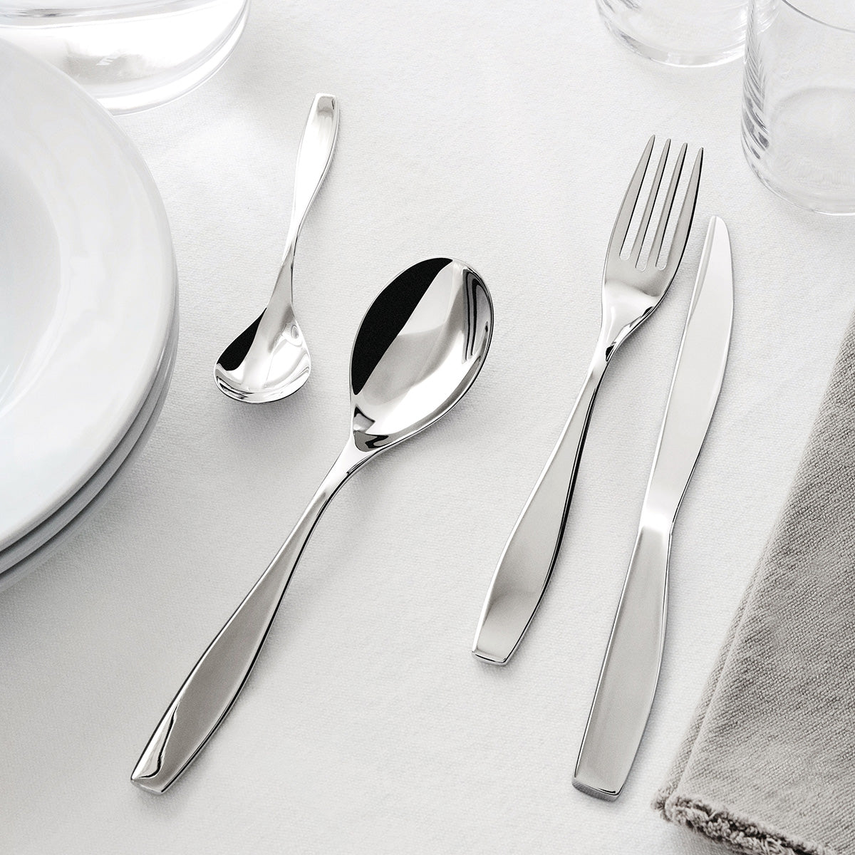 Alessi Duna bestek, close-up van vork, mes en lepels bij bord en glas