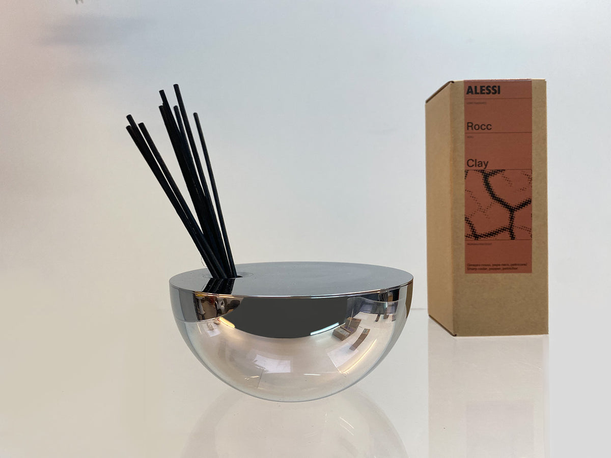Alessi Rocc diffuser Clay: rvs container met stokjes naast de verpakking