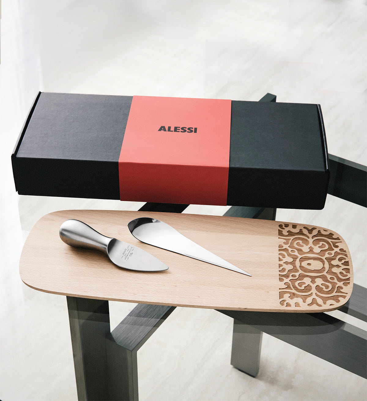 Serveerplank met Mami kaasmes en Antechnicus kaasmes, geschenkdoos op de achtergrond