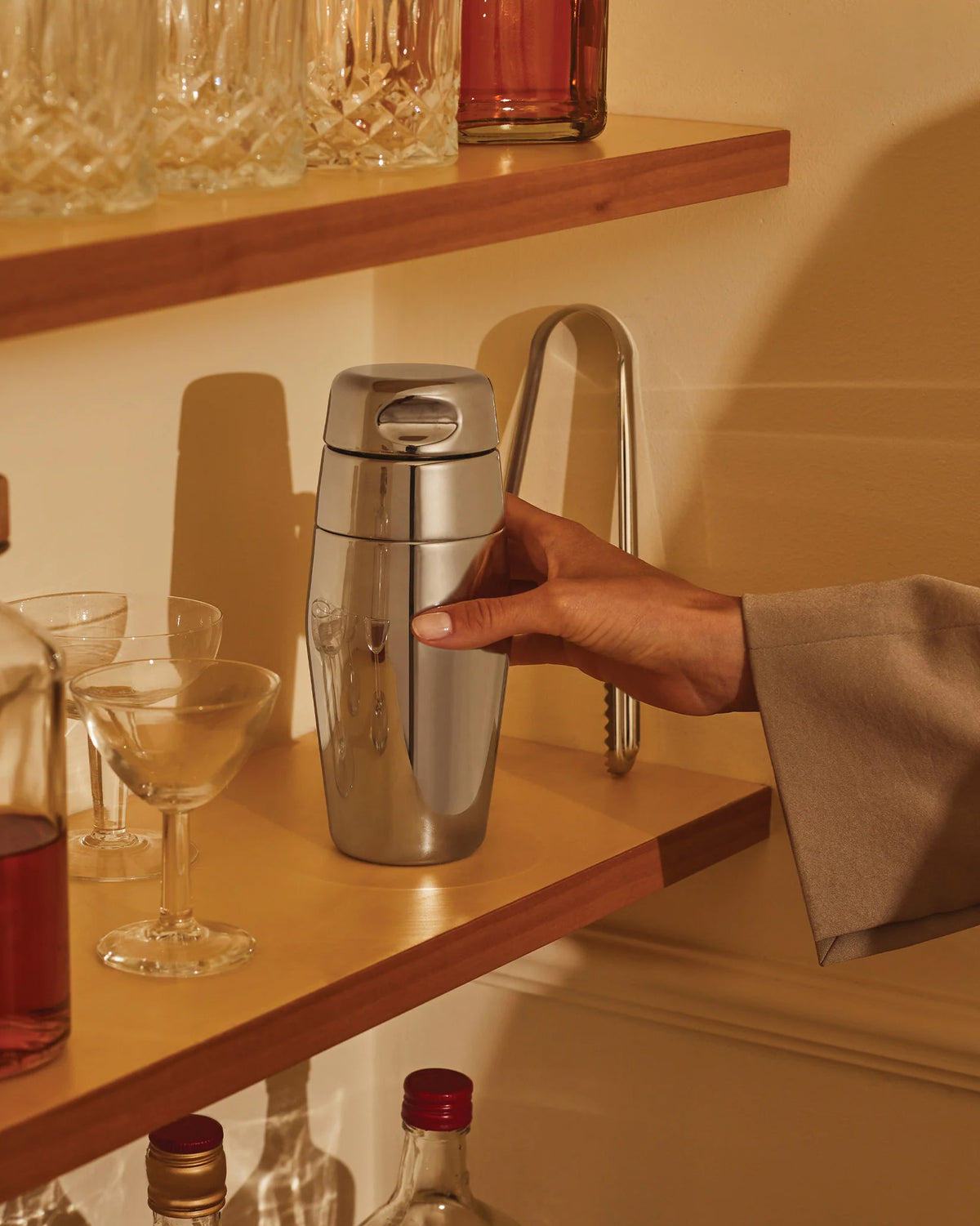Cocktailshaker "870" van Alessi, vastgehouden op een barplank
