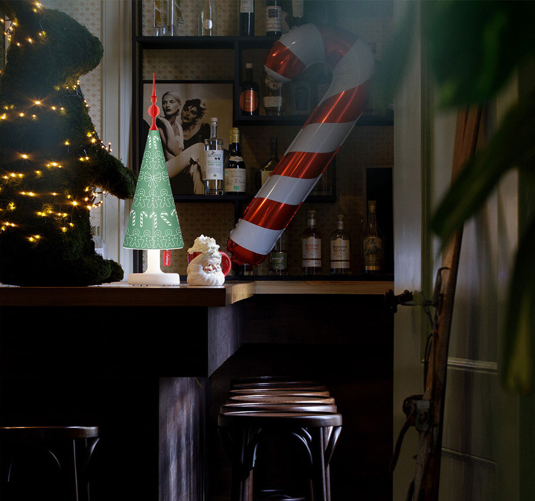 fatboy Edison the petit tafellamp met groene boomkap, brandend op een barblad