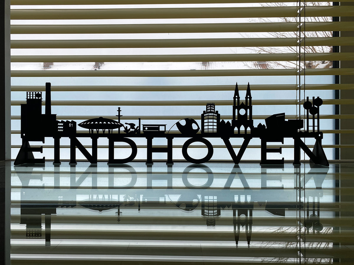 Kleine Eindhoven-skyline van zwart hout, neergezet voor een raam