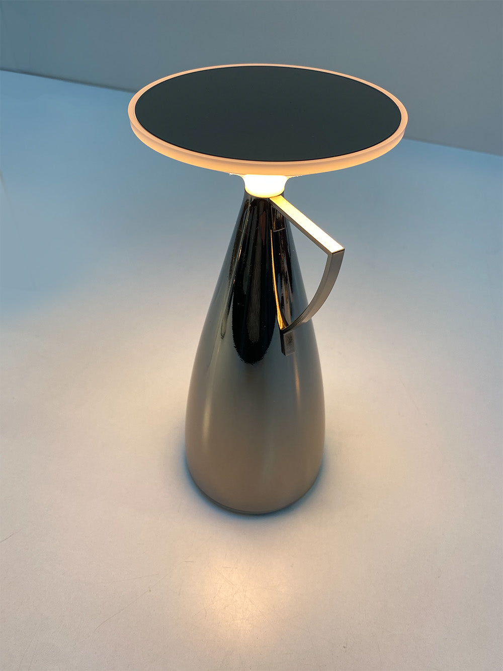 Kartell Camomille tafellamp, bovenaanzicht met brandend licht, titanium metallic