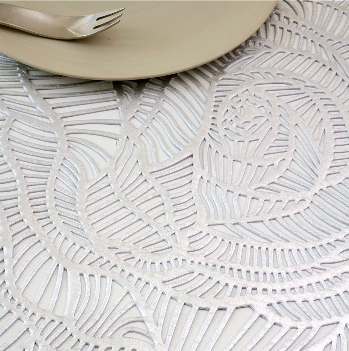 Detail of openwork rose motif in silver, with plate and fork on top
