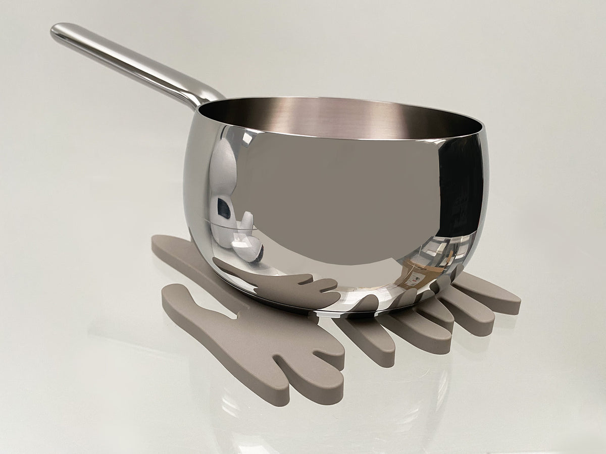 Alessi Barkforpan onderzetter in warmgrijs, met pan erop geplaatst