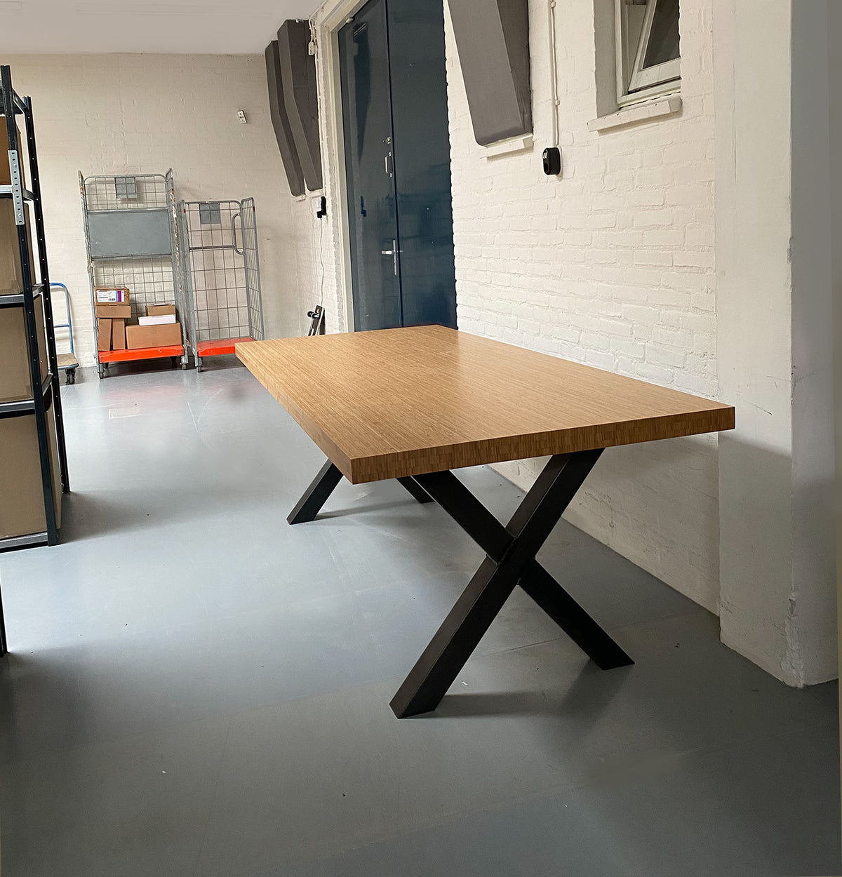 Bamboo table with black metal cross legs, side view