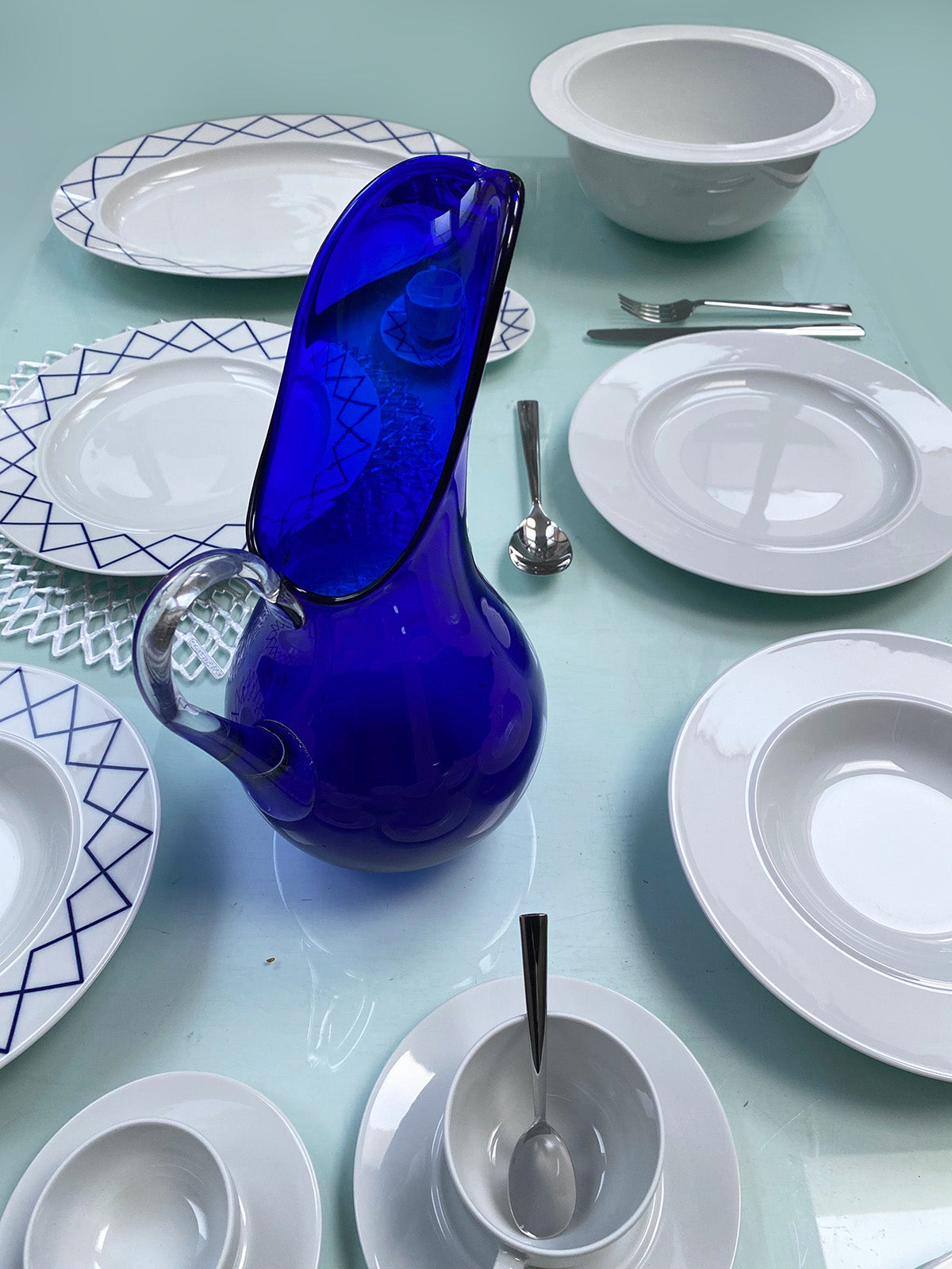 Alessi diner bord My Beautiful China naast andere delen van de serie en een blauwe glazen kan