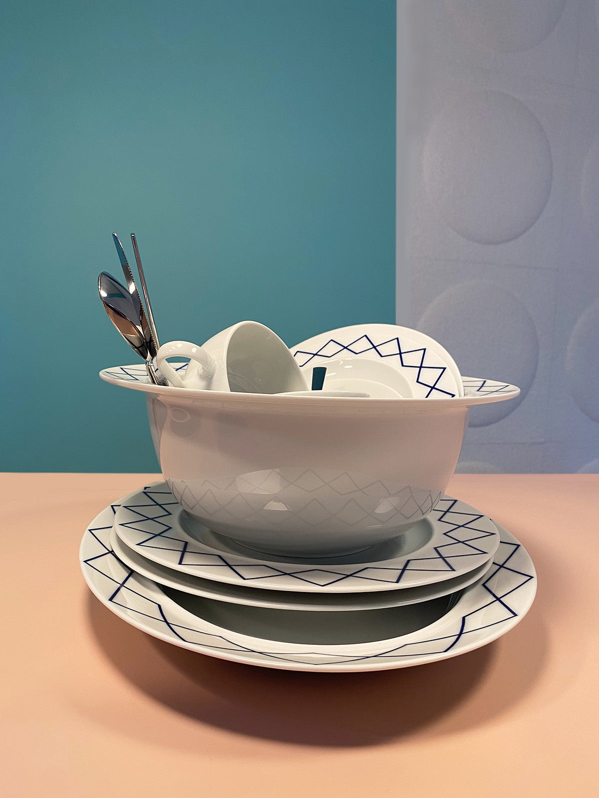 Bowl stacked with plates from the same series, with cutlery inside