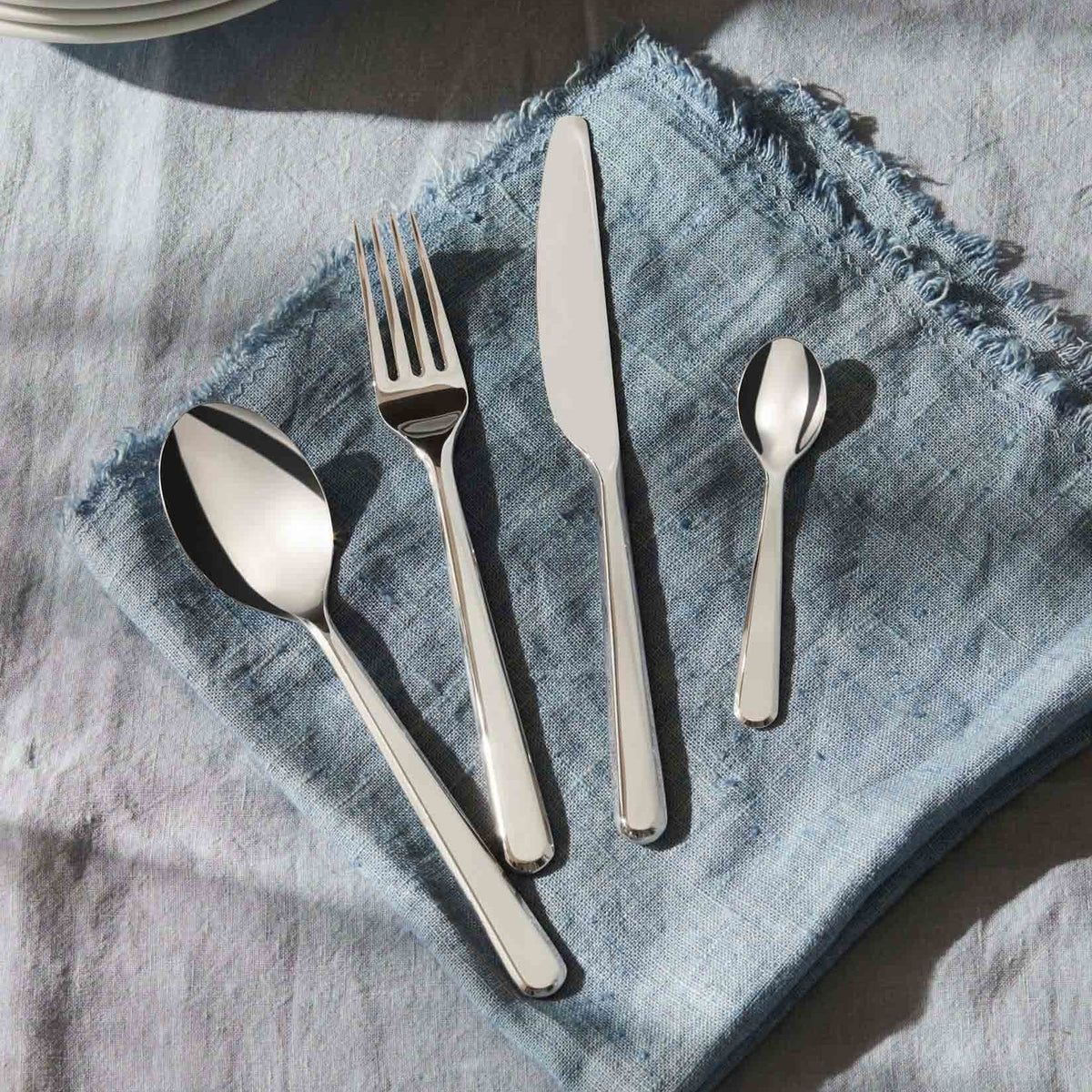 Amici bestekset van Alessi: lepel, vork, mes en koffielepel in 18/10 rvs op tafel