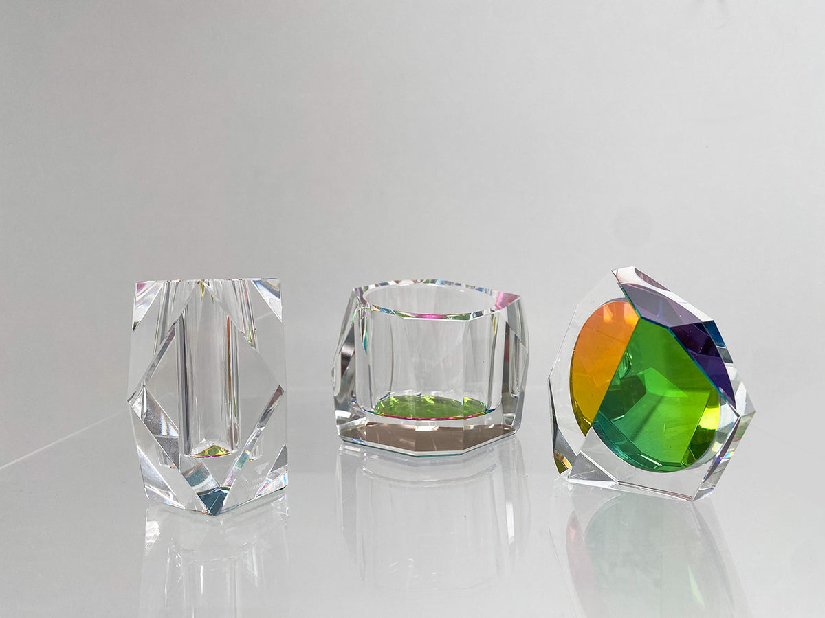Drie kristallen Rainbow-vormen van Alessi naast elkaar, waaronder de kleine vaas