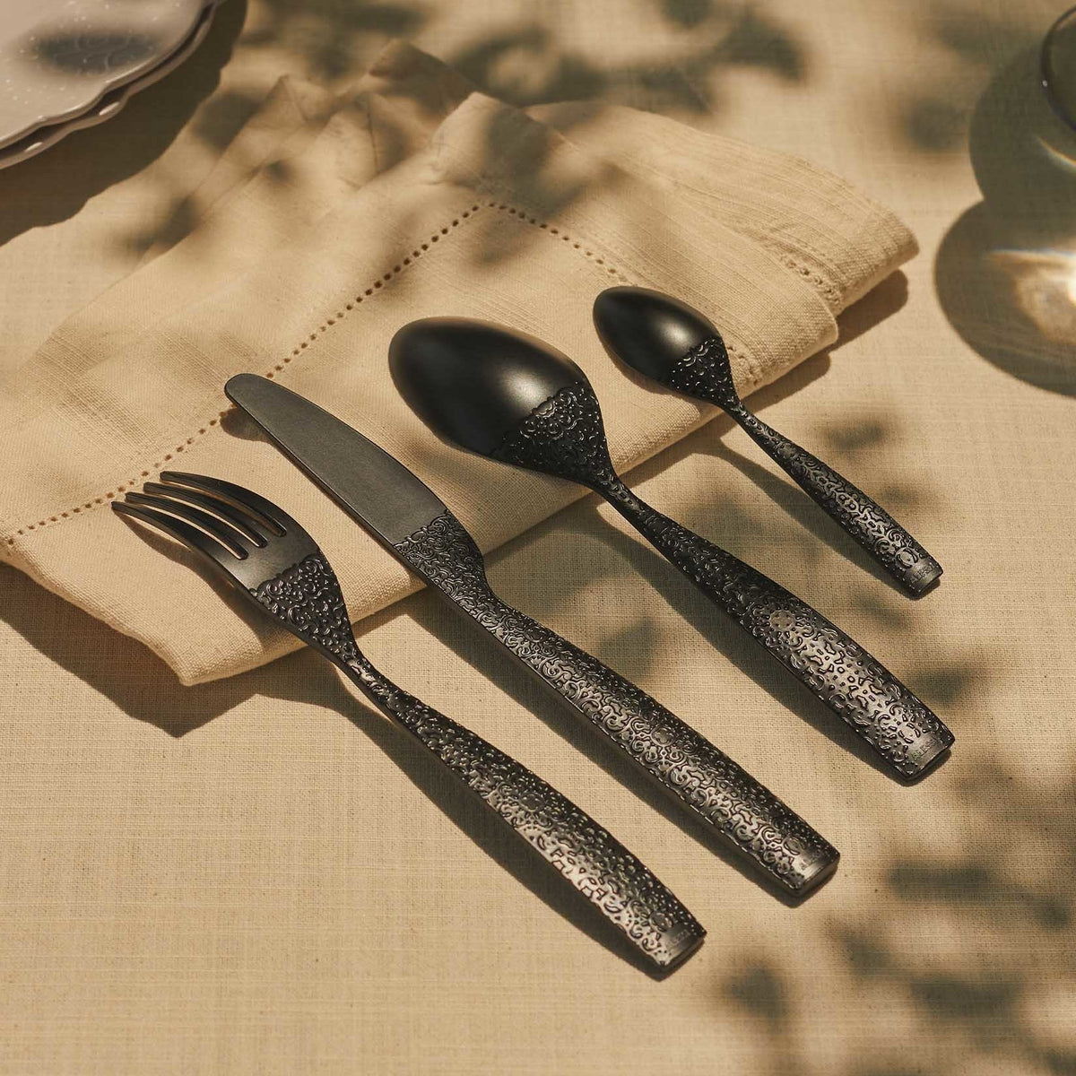 Alessi Dressed En Plein Air bestekset in zwart melamine, achterzijde met reliëfpatroon op tafel