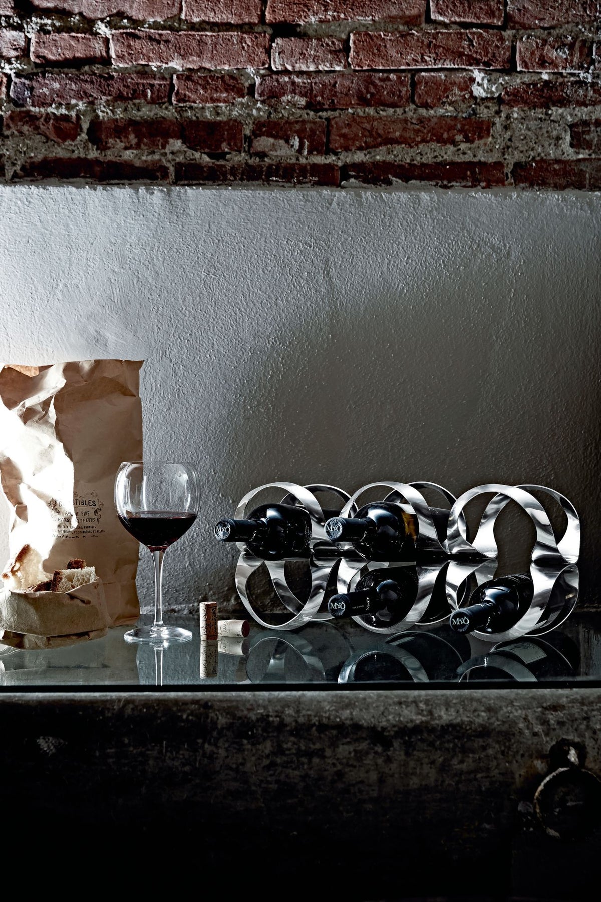 Alessi Ribbon wine rack filled with wine bottles, side view