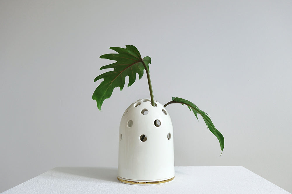 Alessi Fly's Eye Vase, lage vaas van Kasia Zareba in wit met gouden bies, met geperforeerde koepelvorm
