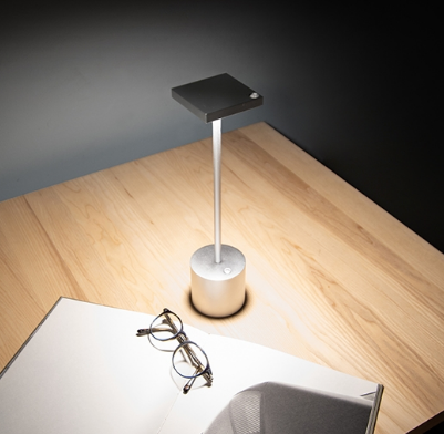 Liberty rechargeable lamp in silver, detail of cup and base, lit light