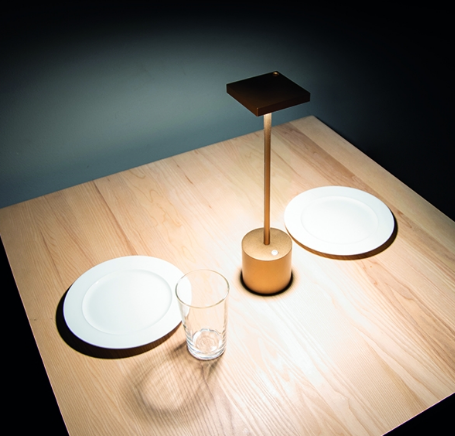 Alessi Liberty rechargeable lamp in gold, lit, top view at an angle