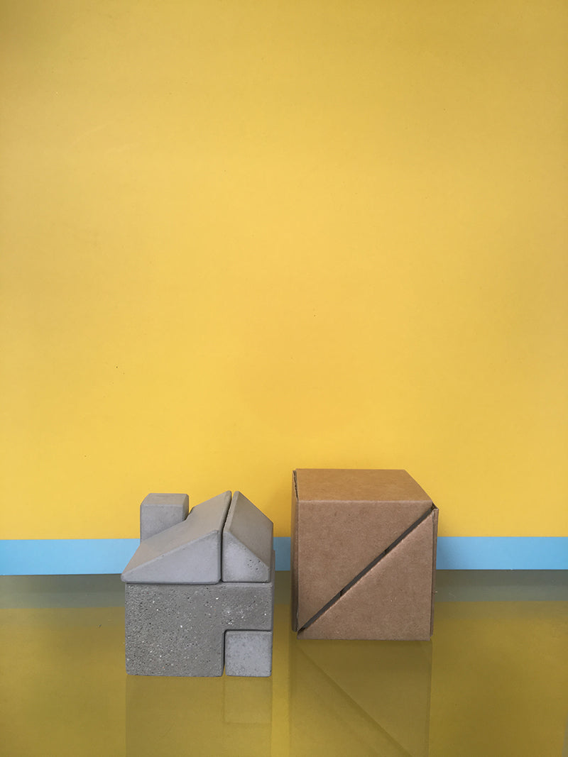 Little House eindhoven bouwsteen naast kartonnen verpakking, grijs beton