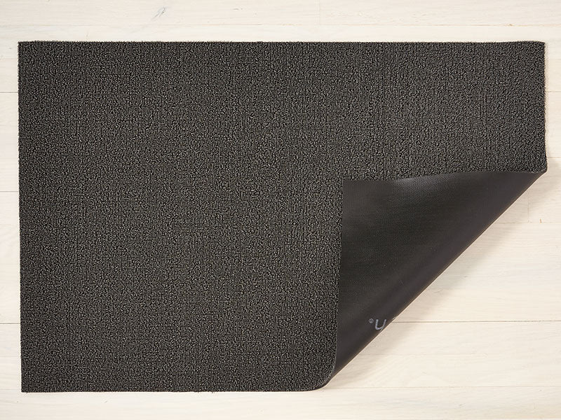Chilewich Solid Mercury deurmat, omgeslagen hoek toont vinyl onderlaag