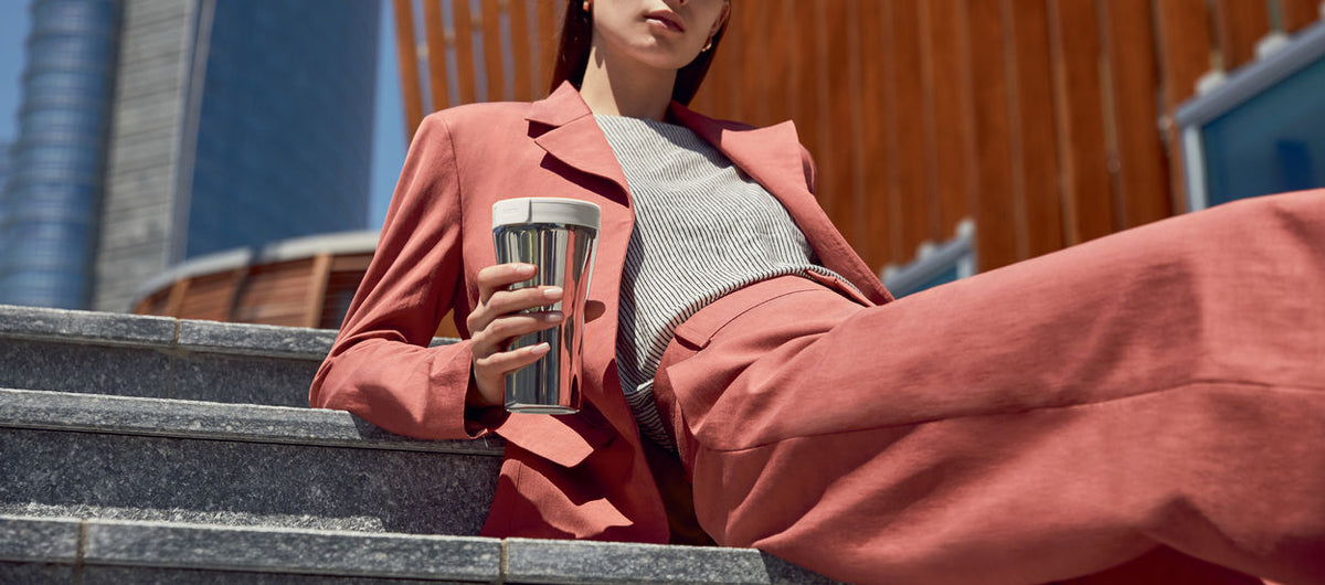 Alessi Caffa drinkbeker met wit deksel, in de hand
