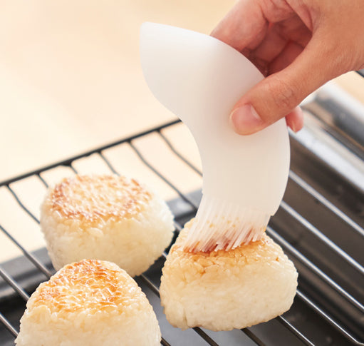 Happy schraper met kwast in vogelvorm, wit, in gebruik voor bestrijken van rijstballen