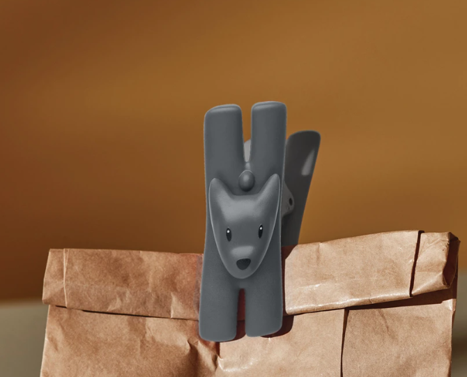 Alessi Giampo clip als hond, zwart, bevestigd op een papieren zak