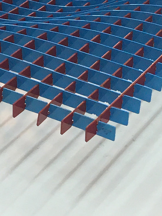 Detail van het piramidevormige metalen oppervlak in rood en blauw