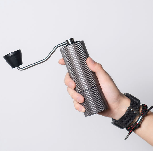 Alessi koffiemolen C2 in antraciet, in de hand met slinger uitgeklapt