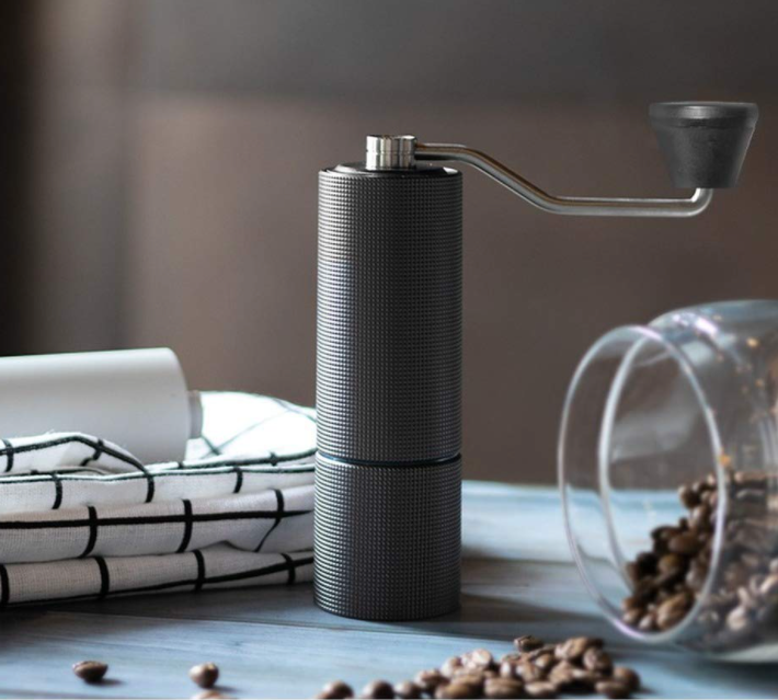 Alessi koffiemolen C2 in antraciet tussen theedoeken en koffiebonen