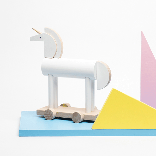Speelgoedpaard in eenhoornvorm, blank houten, op basis met wieltjes, ontwerp Pavla Bohácová.