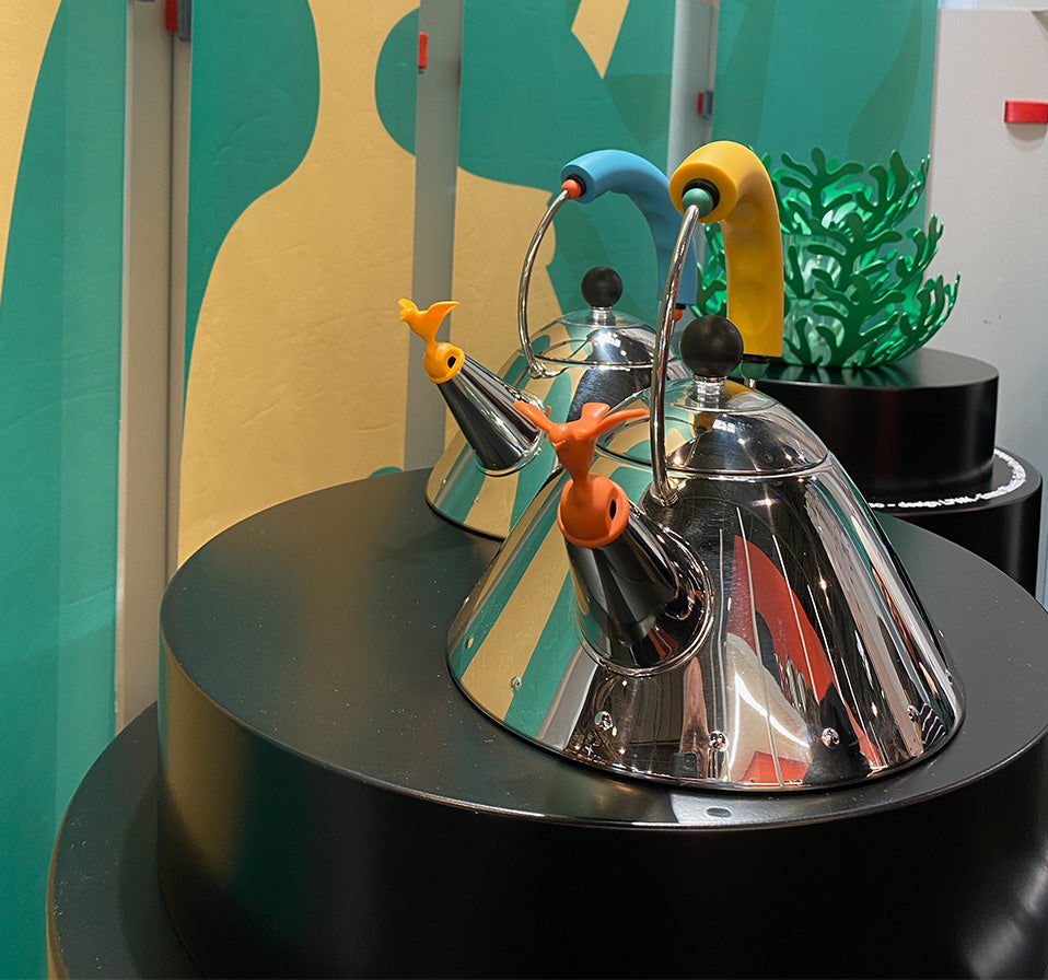 Twee fluitketels Graves Y van Alessi naast elkaar, met blauw en geel handvat