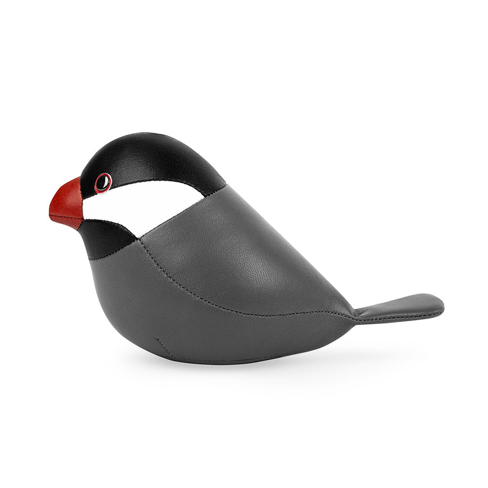 Side view of small rice bird paperweight, black-grey with red beak