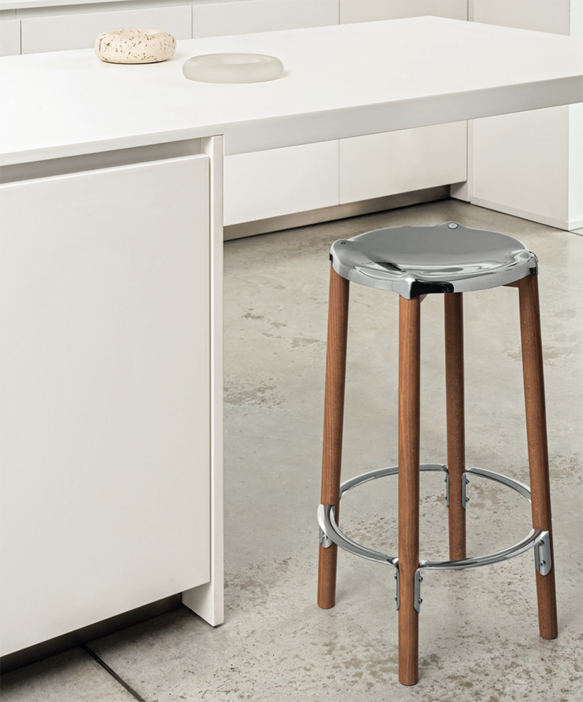 Alessi Poêle bar stool in a kitchen, with steel seat and wooden legs