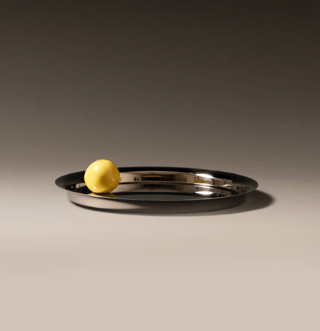 Kuru Kuru dienblad van Alessi, detail met gele bol op het glanzende oppervlak