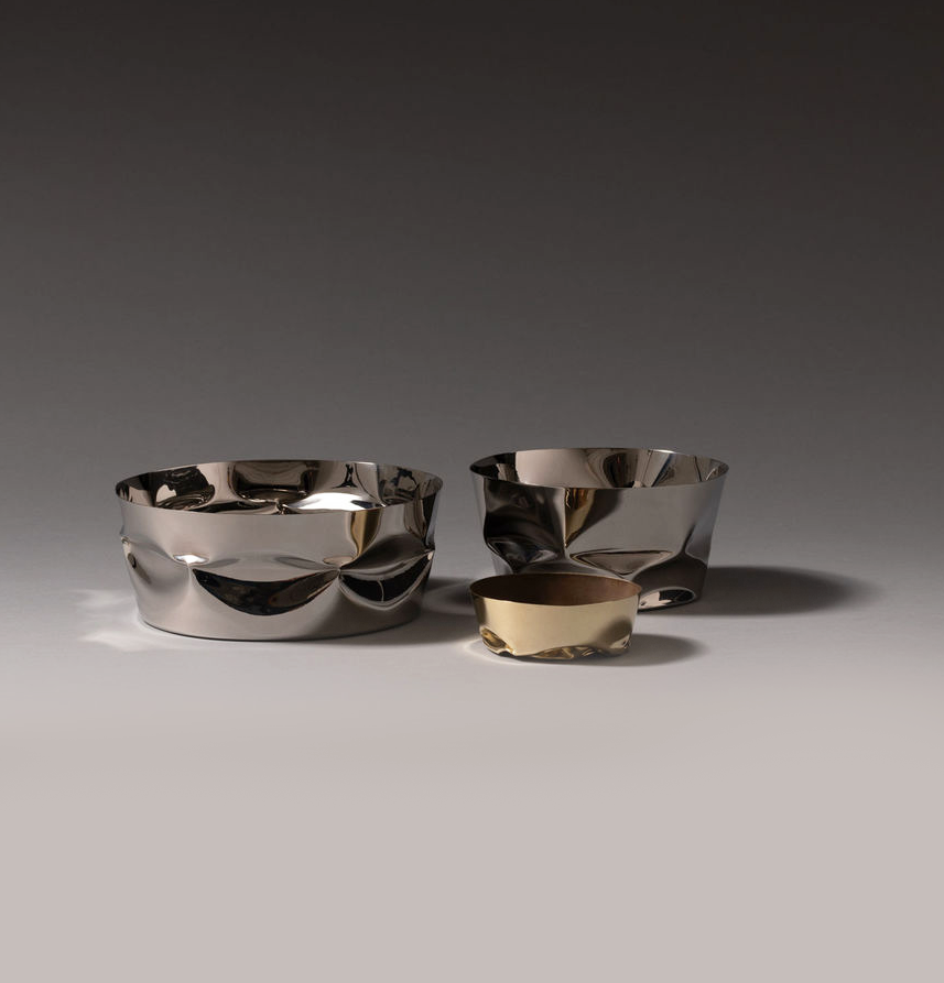 Alessi Compressioni mand naast kleinere maten uit de serie, in staal en goudkleur