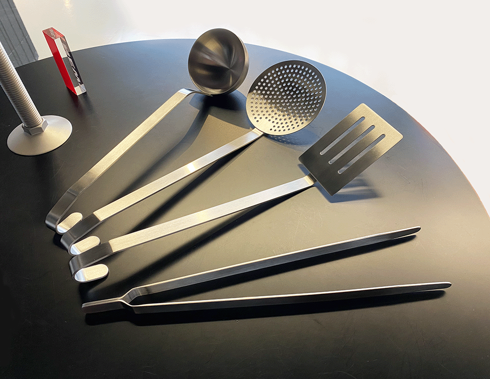 Convivio kitchen tongs next to other scoop utensils from the series