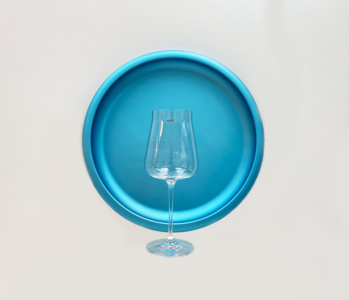 Alessi Eugenia witte wijn glas op ronde blauwe schaal