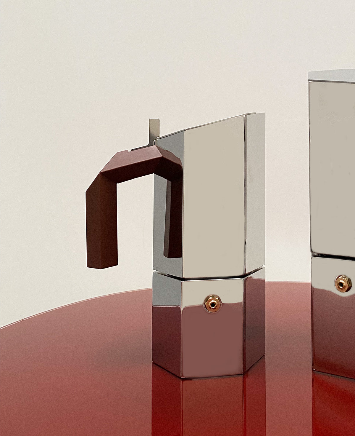 Detail van het handvat van de Alessi Menhir koffiemaker, in rvs met bordeaux handvat.