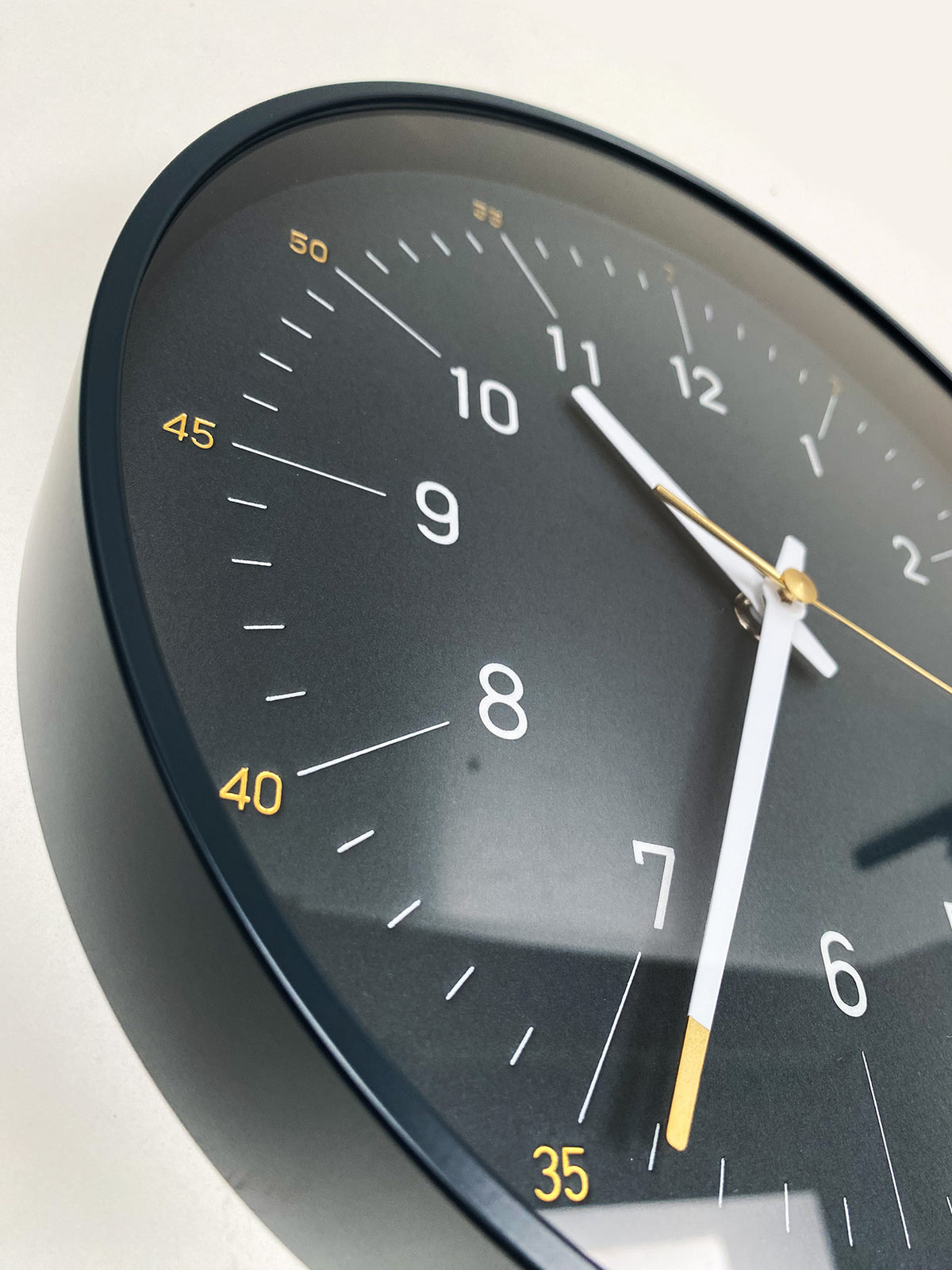Close-up at an angle of the Essence Dark Navy clock, index and hands in detail