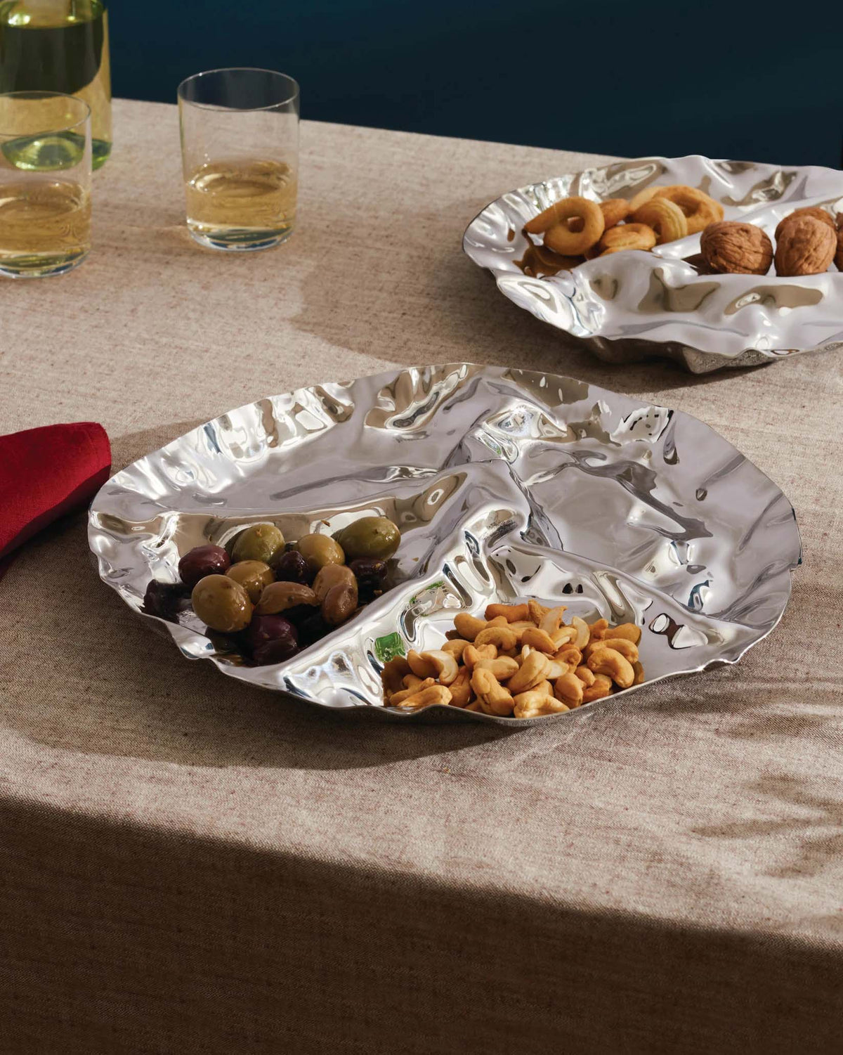 Pepa schaal van Alessi met olijven en noten, twee exemplaren op tafel