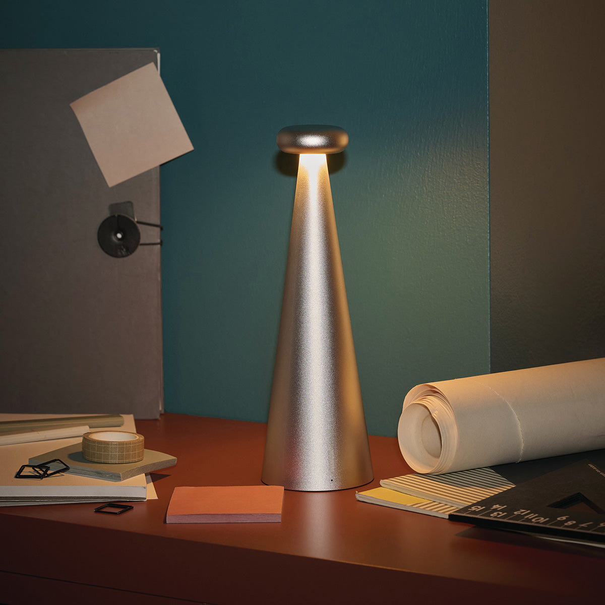 Alessi Bedin lamp in grey, lit on a desk