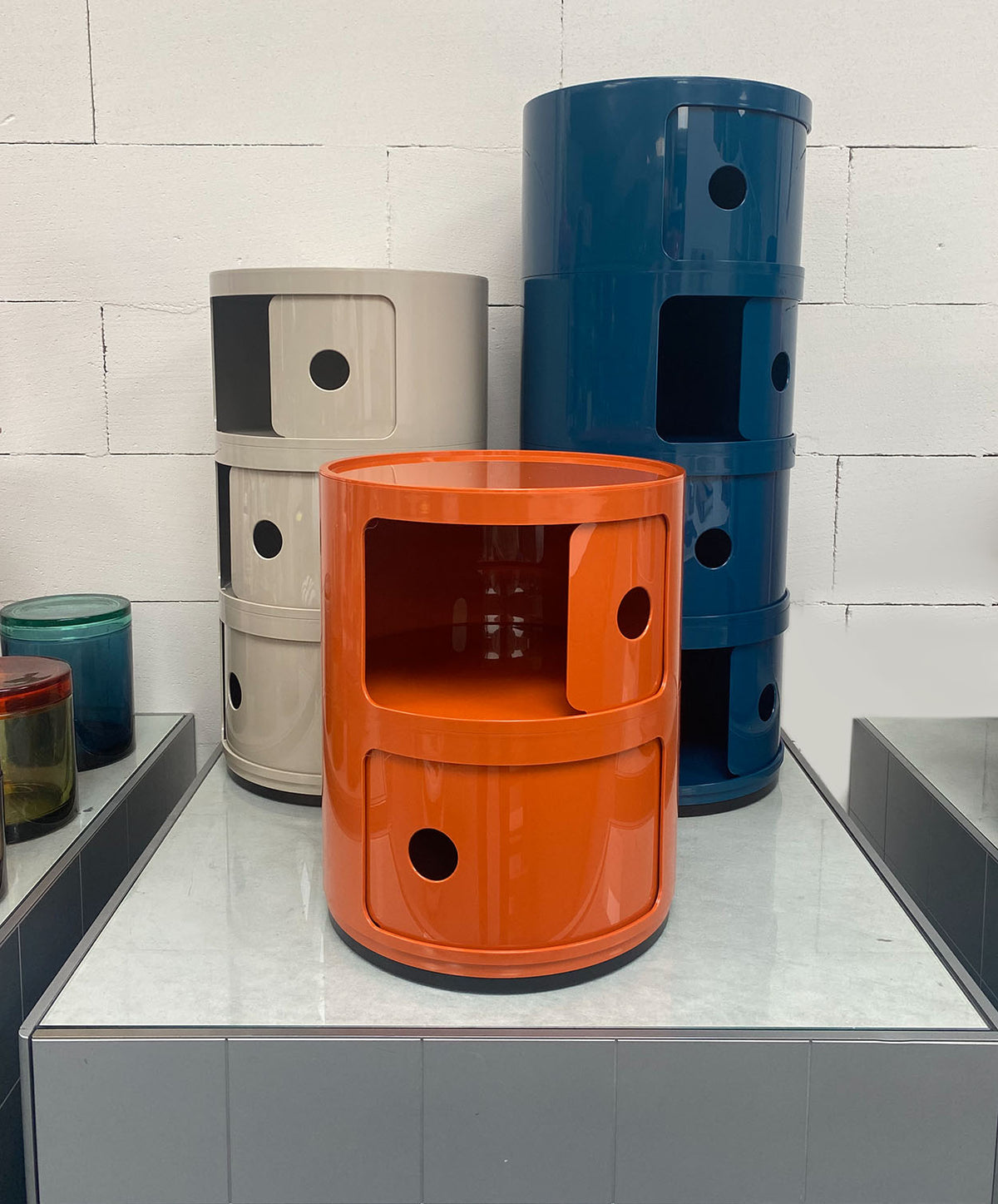 Kartell Componibili opbergkast in donkerblauw, naast grijze en oranje versie.