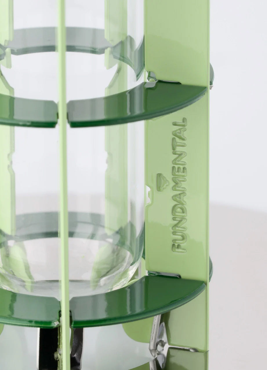Detail van de kleine groene vaas met logo Fundamental en glazen buisje
