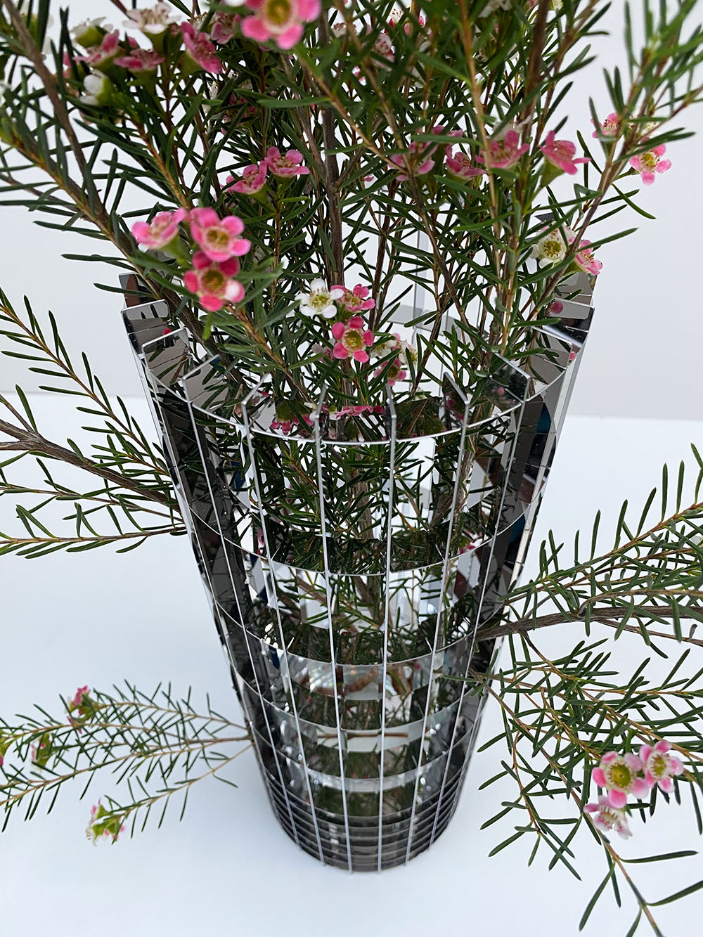 Detail van de grote Gravity-vaas met bloemen, bovenaanzicht van het glazen grid.