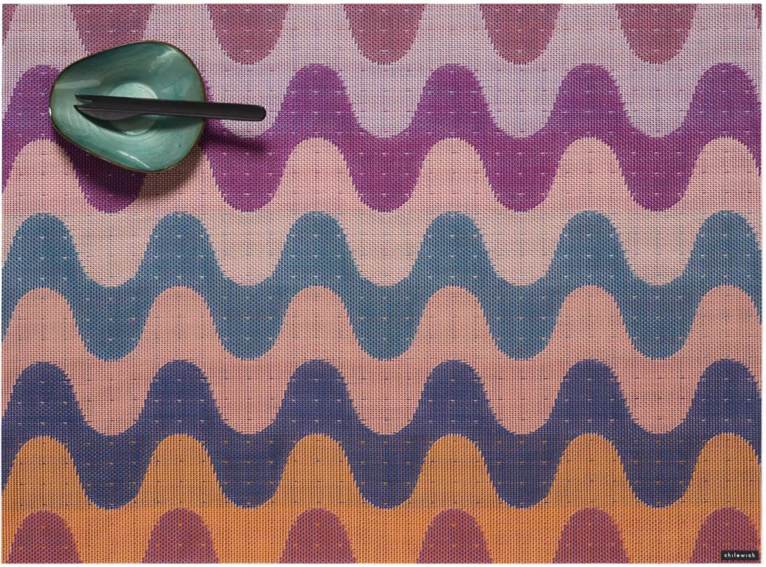 Chilewich placemat in pink, orange and blue tones, with green bowl and cutlery