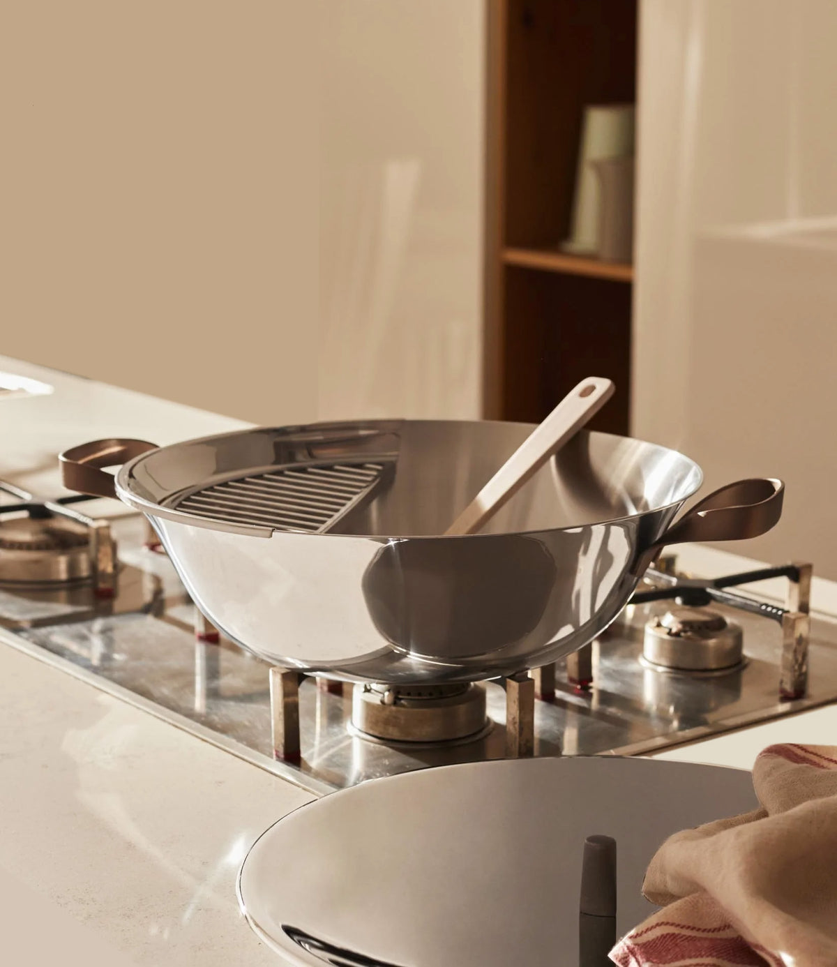 Wok EDO van Alessi met deksel, in gebruik op gasfornuis